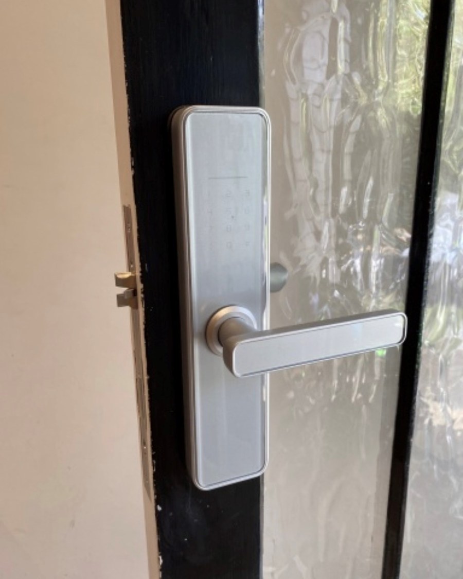 Silver smart lock on a black painted glazed timber door
