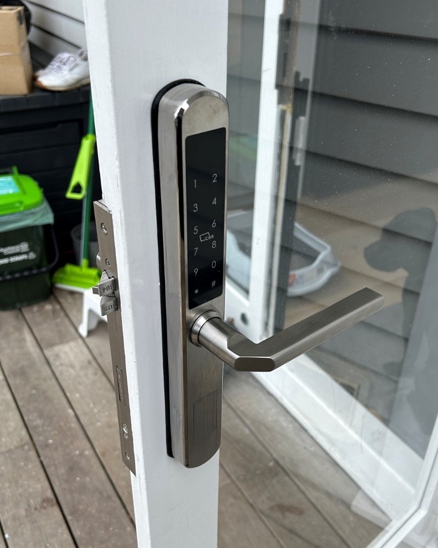 Brushed stainless slimline smart lock on a white timber french door